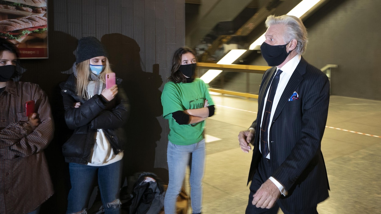 Gilbert Rozon marche devant des femmes au palais de justice de Montréal.