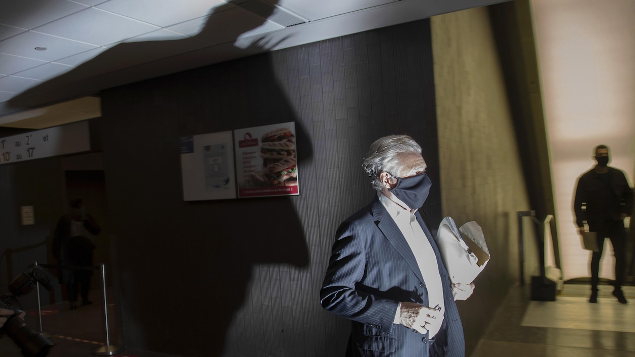 Gilbert Rozon marche dans un couloir du palais de justice de Montréal.
