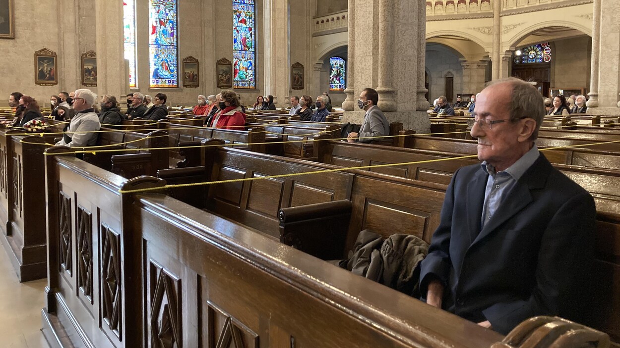 Gilles Kègle assis sur un banc d'église.