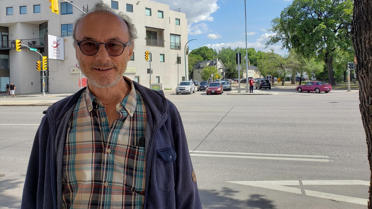 Gilles Lesage sourit pour une photo. Il est à l'extérieur, devant une rue de Winnipeg.