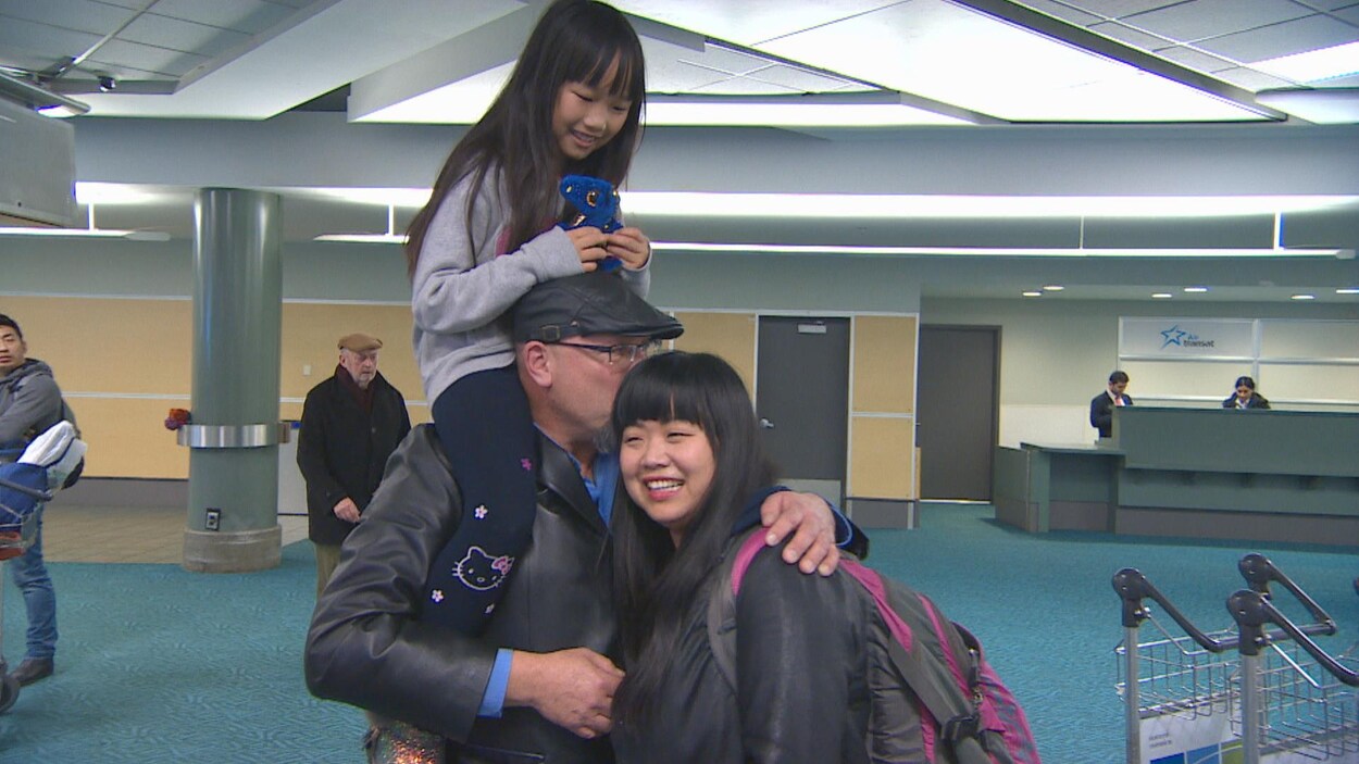 Monte Gisborne embrasse sa femme Daniela Luo alors qu'il porte sa fille sur ces épaules.