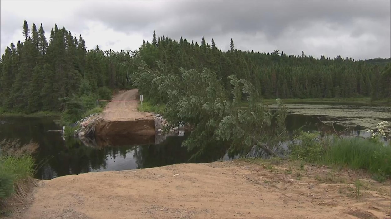 Un chemin forestier emporté par un glissement de terrain au-dessus d'un cours d'eau.