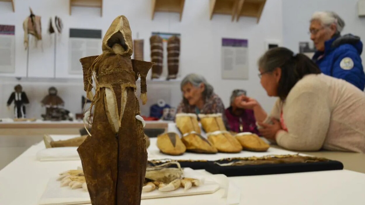 Des gens discutent autour d'une table sur laquelle sont posés des objets patrimoniaux.