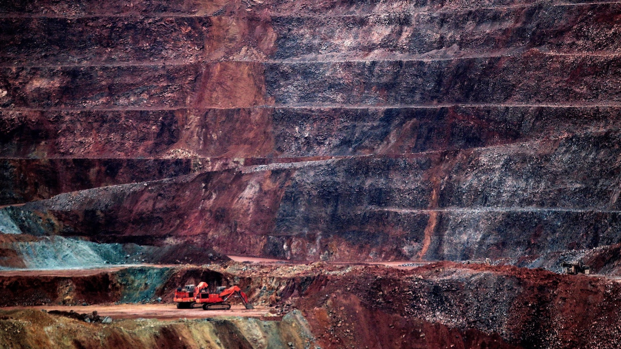 Une petite grue rouge tranche sur l'immensité de la mine.