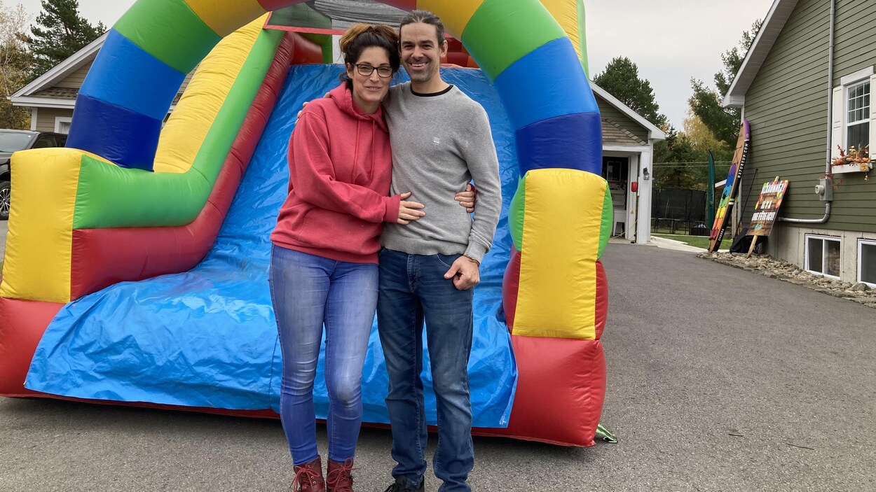 Un homme et une femme devant un jeu gonflable multicolore.