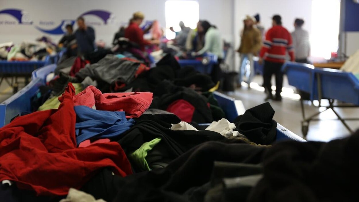 Un gros plan sur un bac rempli de vêtement dans un magasin Goodwill.