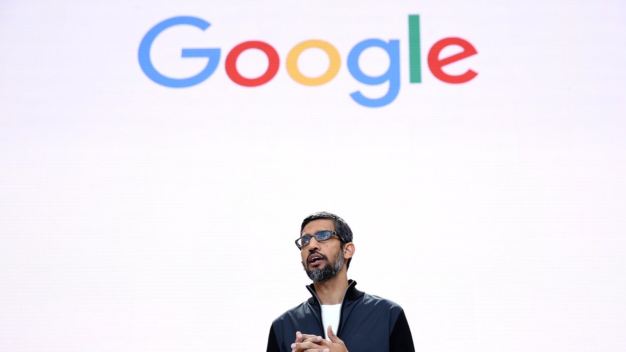 Le PDG de Google, Sundai Pichar, se tient devant un écran blanc sur lequel est inscrit "Google". Le PDG de Google, Sundai Pichar, se tient devant un écran blanc sur lequel est inscrit "Google".
