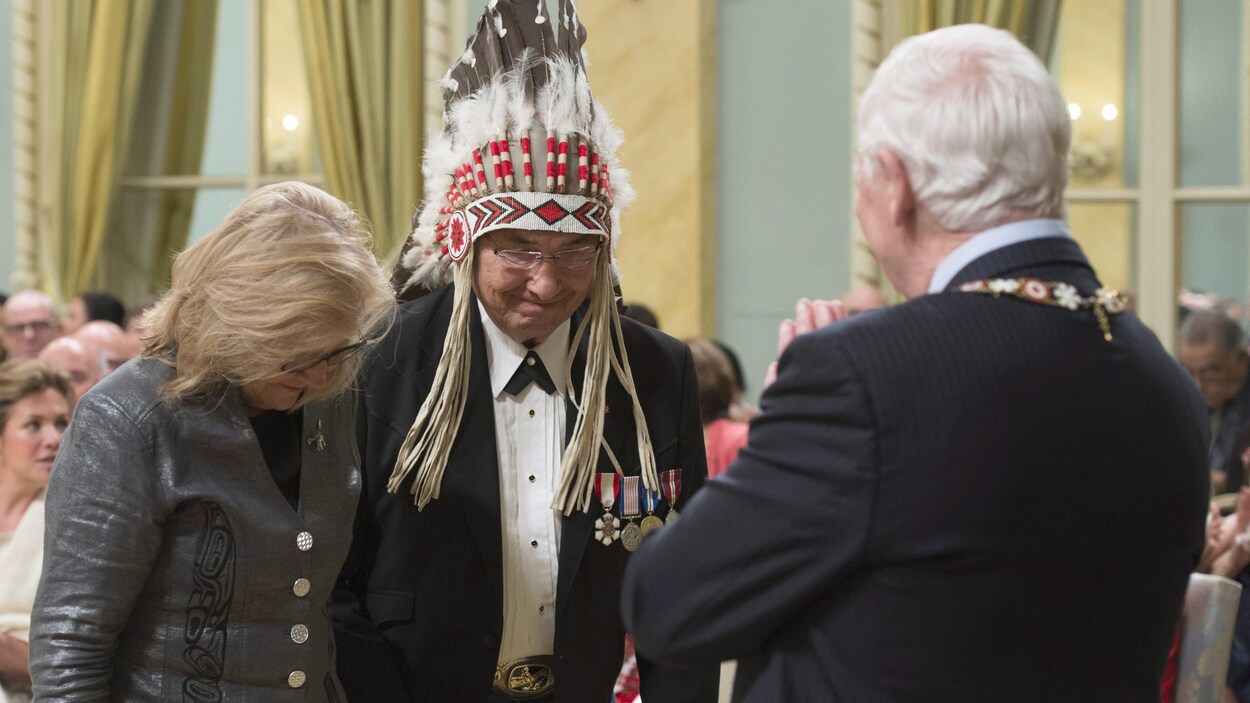 Marie Wilson tient la main de Wilton Littlechild, devant David Johnston, qui est de dos Marie Wilson tient la main de Wilton Littlechild, devant David Johnston, qui est de dos