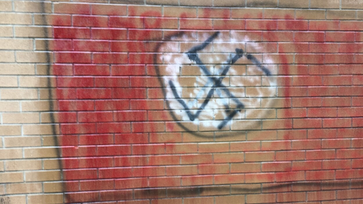 Un graffiti en forme de drapeau canadien avec une croix gammée au centre Un graffiti en forme de drapeau canadien avec une croix gammée au centre