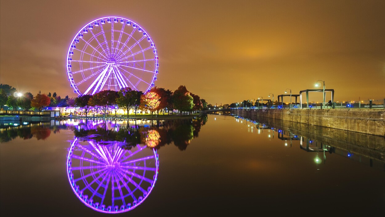 La Grande Roue reflétée dans l'eau à la brunante.