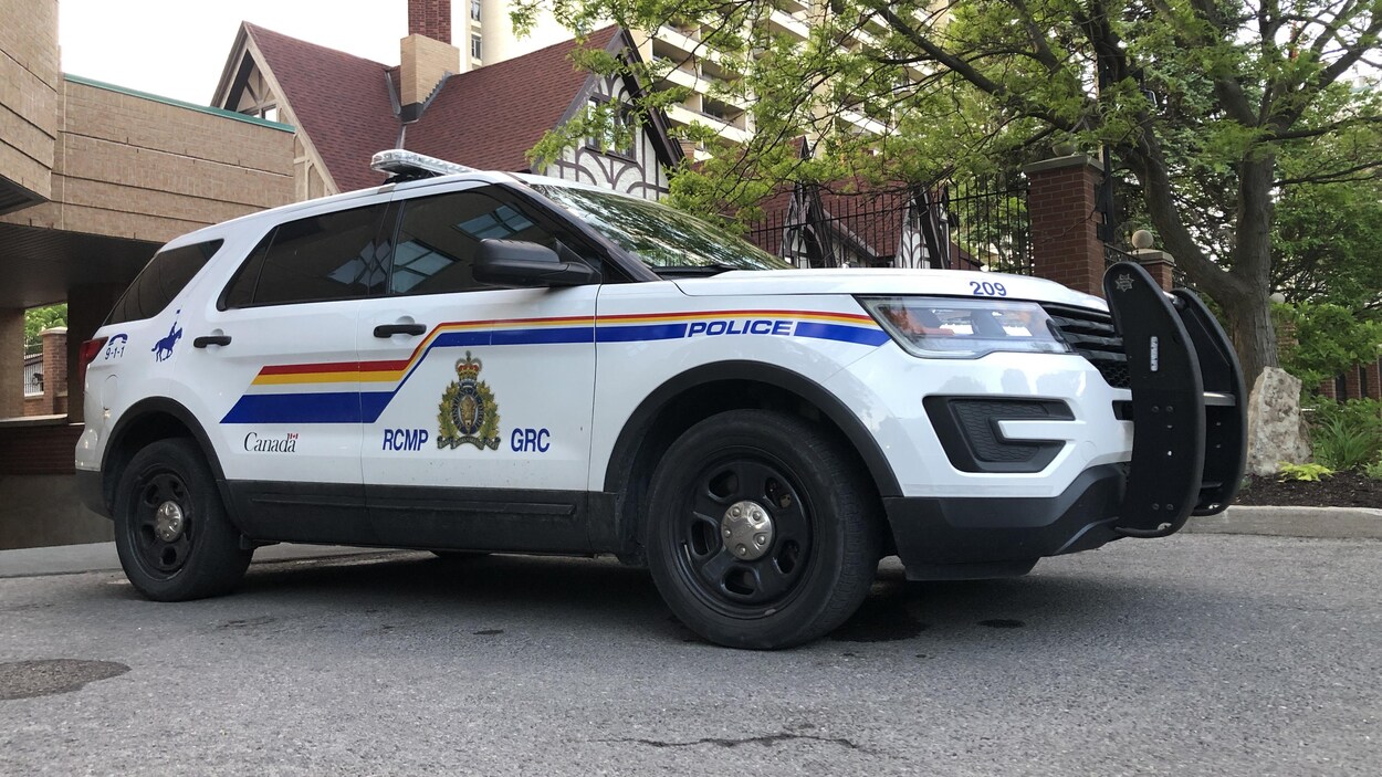 Un véhicule aux couleurs de la GRC stationné près d'un édifice.