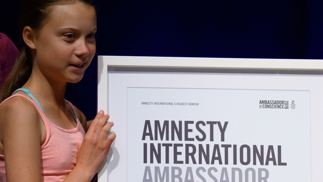 Greta Thunberg reçoit une plaque d'Amnistie Internationale.