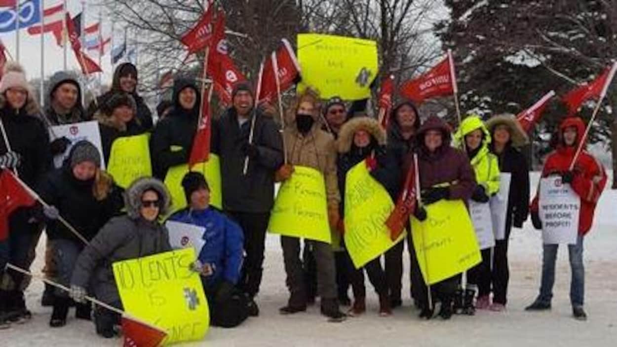 Des membres du syndicat Unifor avec drapeaux et pancartes à Sault-Sainte-Marie. Des membres du syndicat Unifor avec drapeaux et pancartes à Sault-Sainte-Marie.