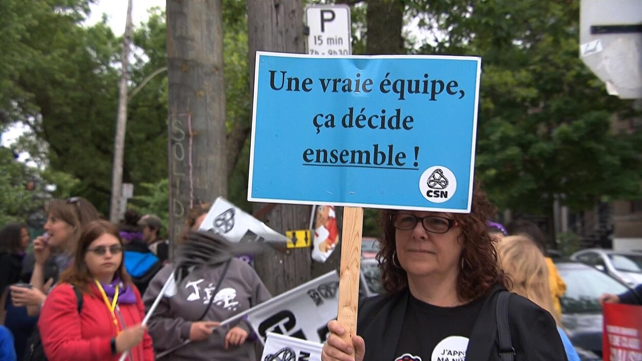 Une éducatrice en grève tient une pancarte sur laquelle on peut lire : « Une vraie équipe, ça décide ensemble!» Une éducatrice en grève tient une pancarte sur laquelle on peut lire : « Une vraie équipe, ça décide ensemble!»
