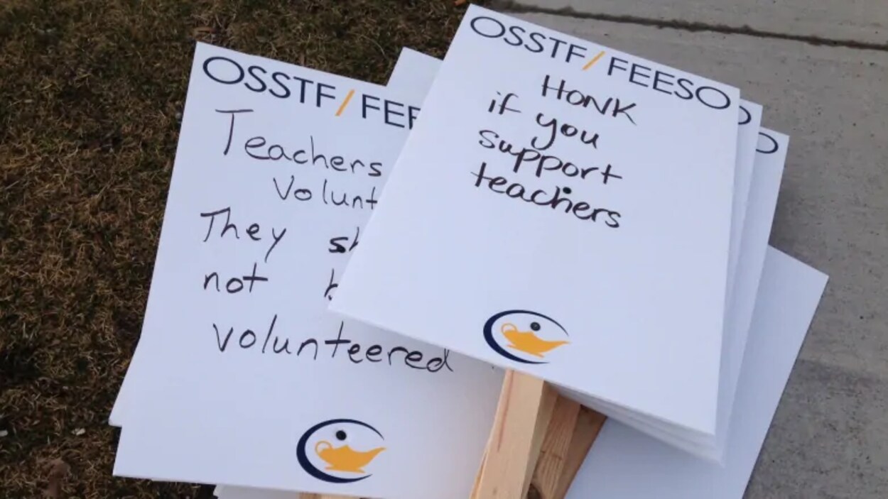 Des pancartes en anglais sont étalées sur un trottoir.