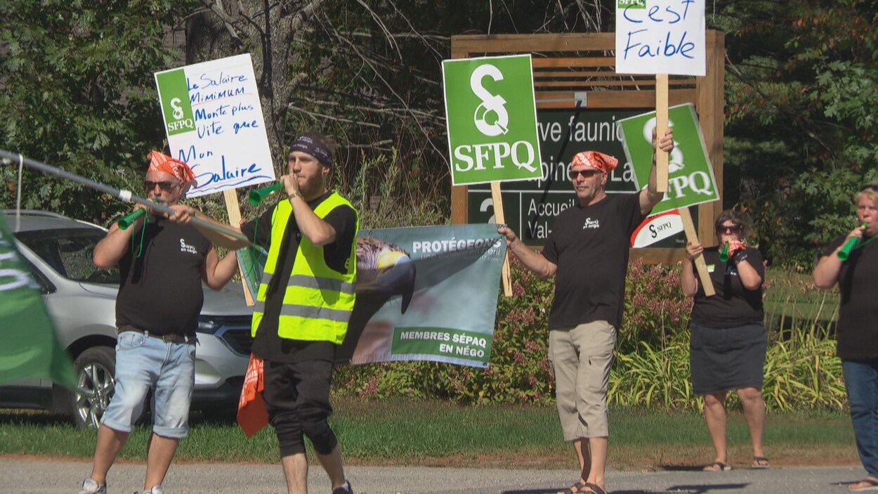 Cinq manifestants brandissent des pancartes sur lesquelles on peut lire : le salaire minimum monte plus vite que mon salaire.