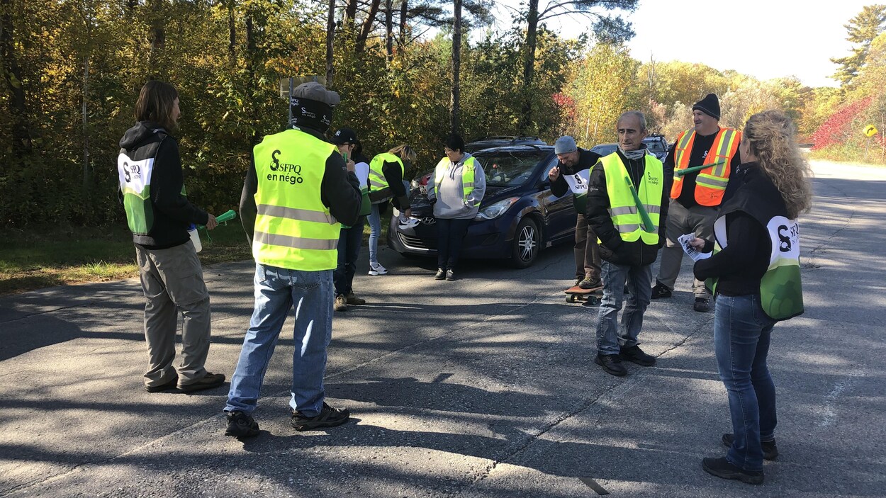 Environ une dizaine d'employés manifestent sur la route menant au parc de Plaisance.