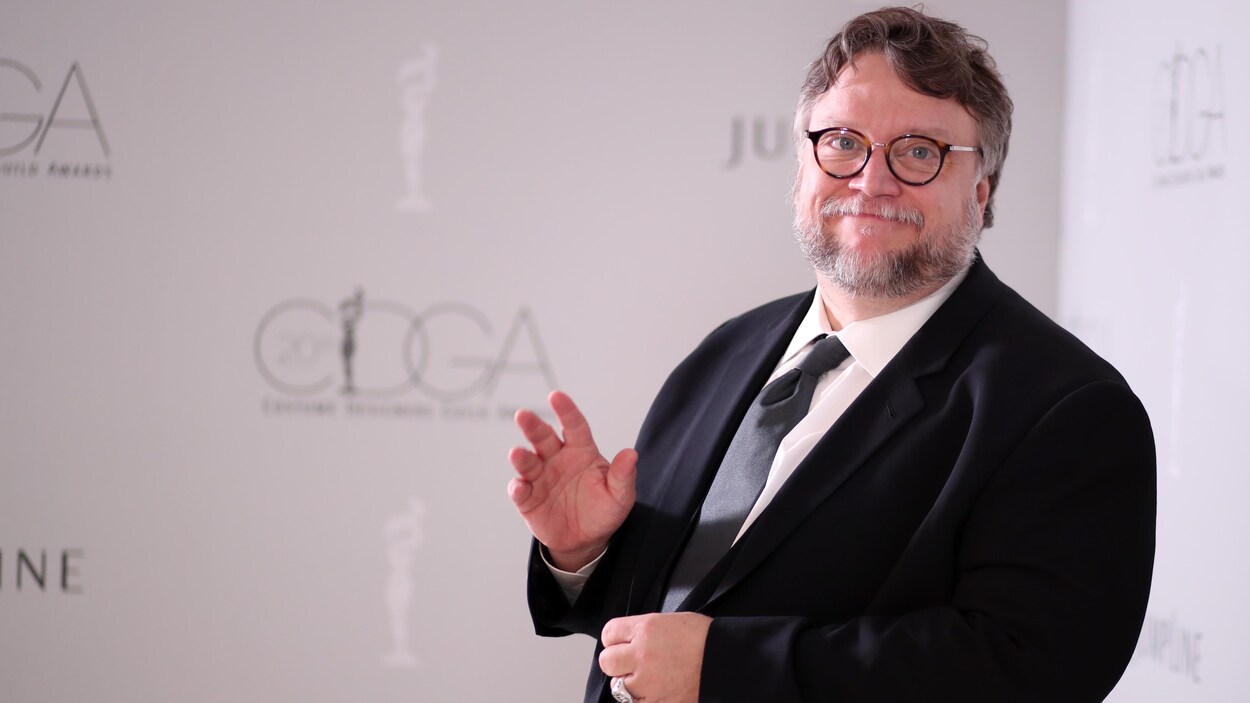 Le réalisateur Guillermo del Toro fait un signe de la main à la caméra. Le réalisateur Guillermo del Toro fait un signe de la main à la caméra.