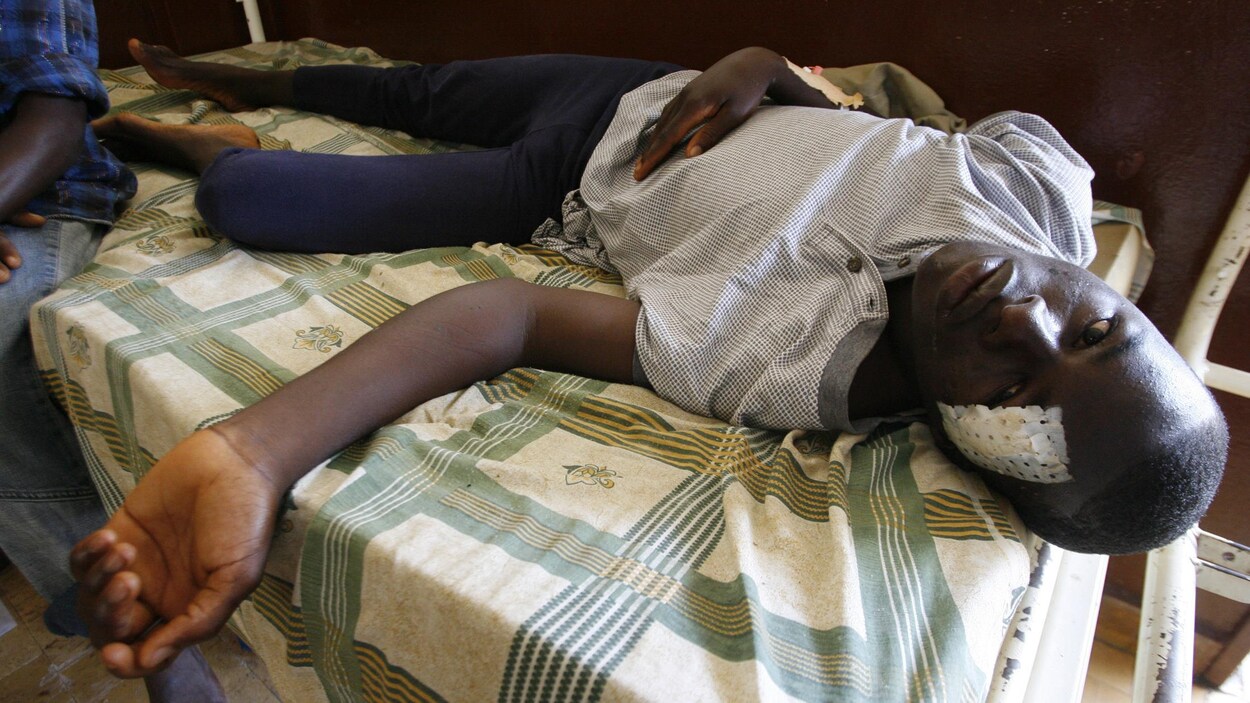 Mamadou Lamine Diallo sur un lit, avec un pansement au front.