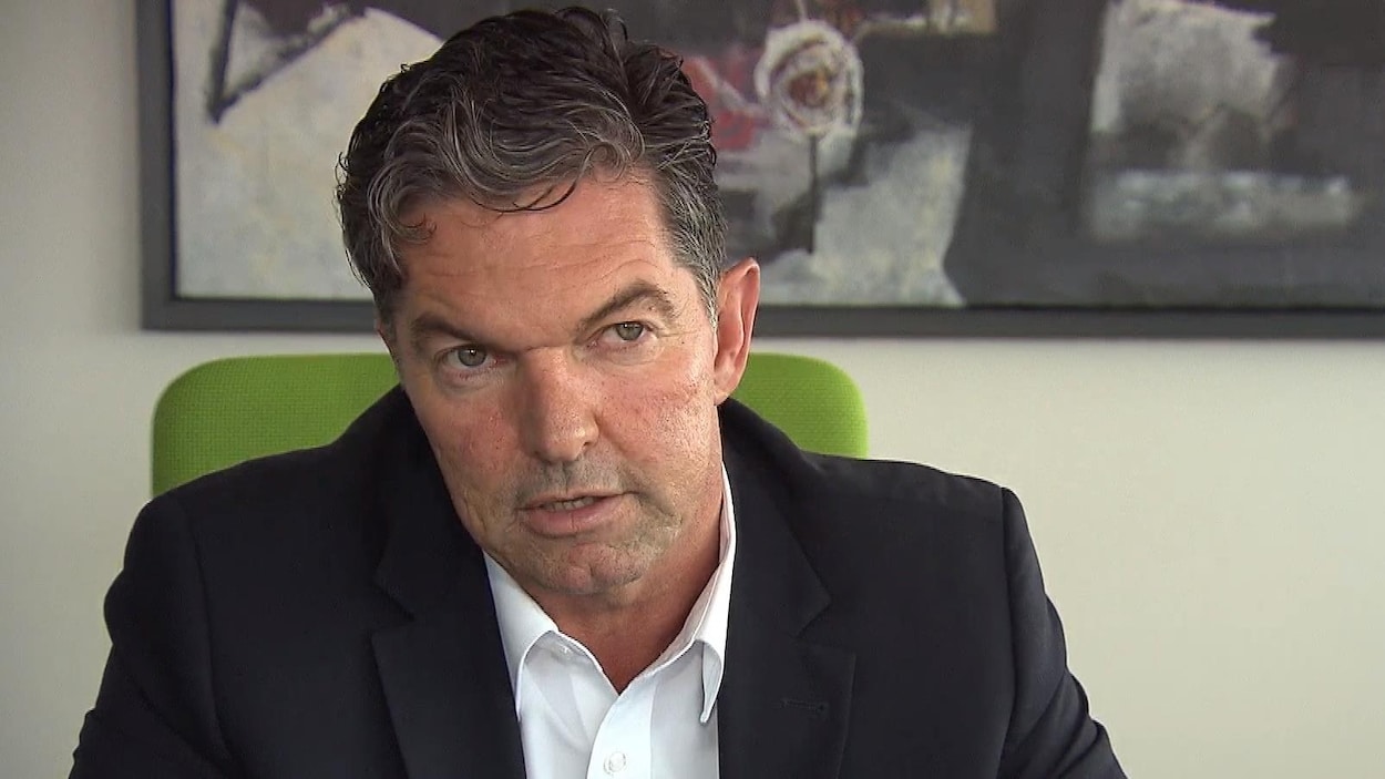 Guy Leclair en entrevue, assis à un bureau.