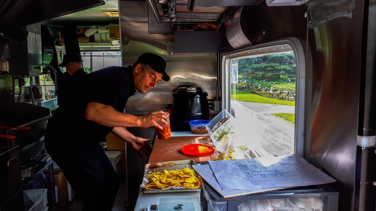 Guy Lévesque, propriétaire de la Saga cuisine nomade, en train de préparer une commande.