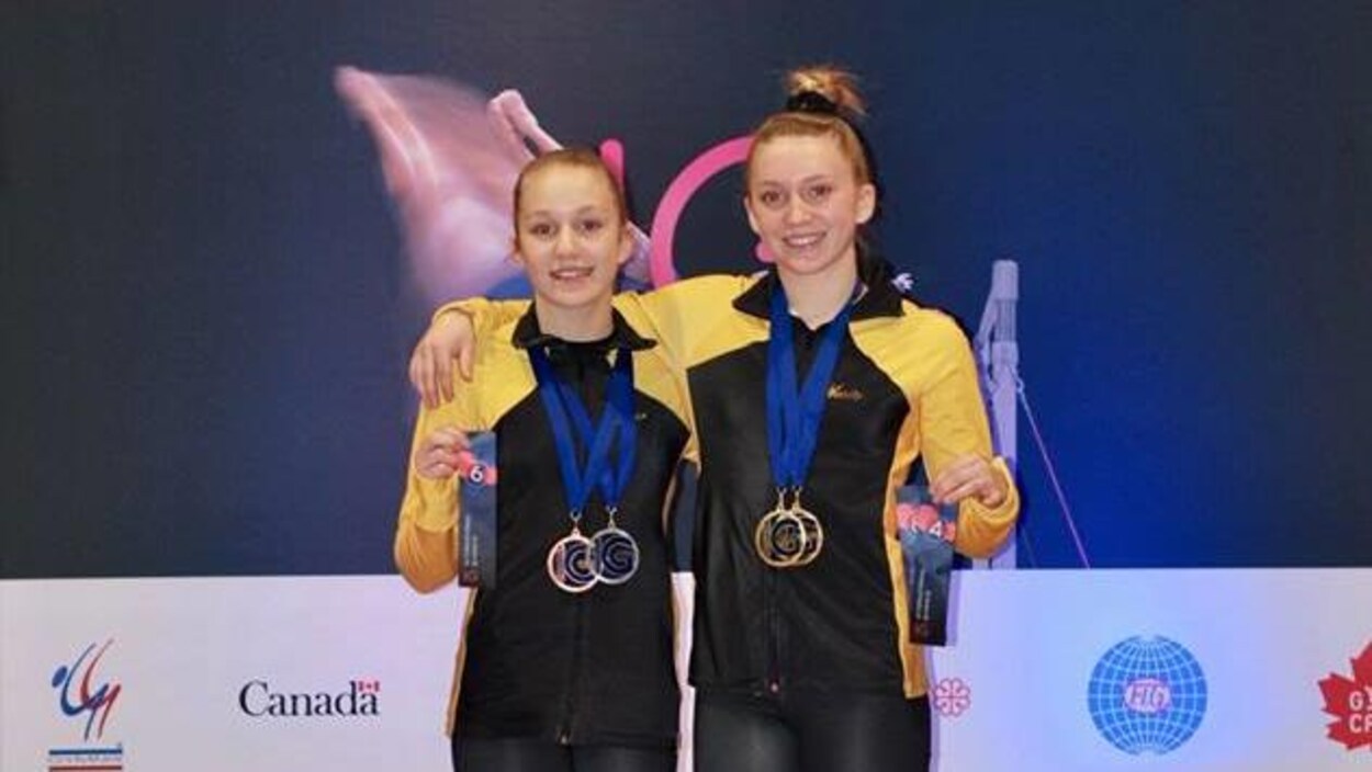Deux jeunes femmes posent avec leurs médailles au cou.