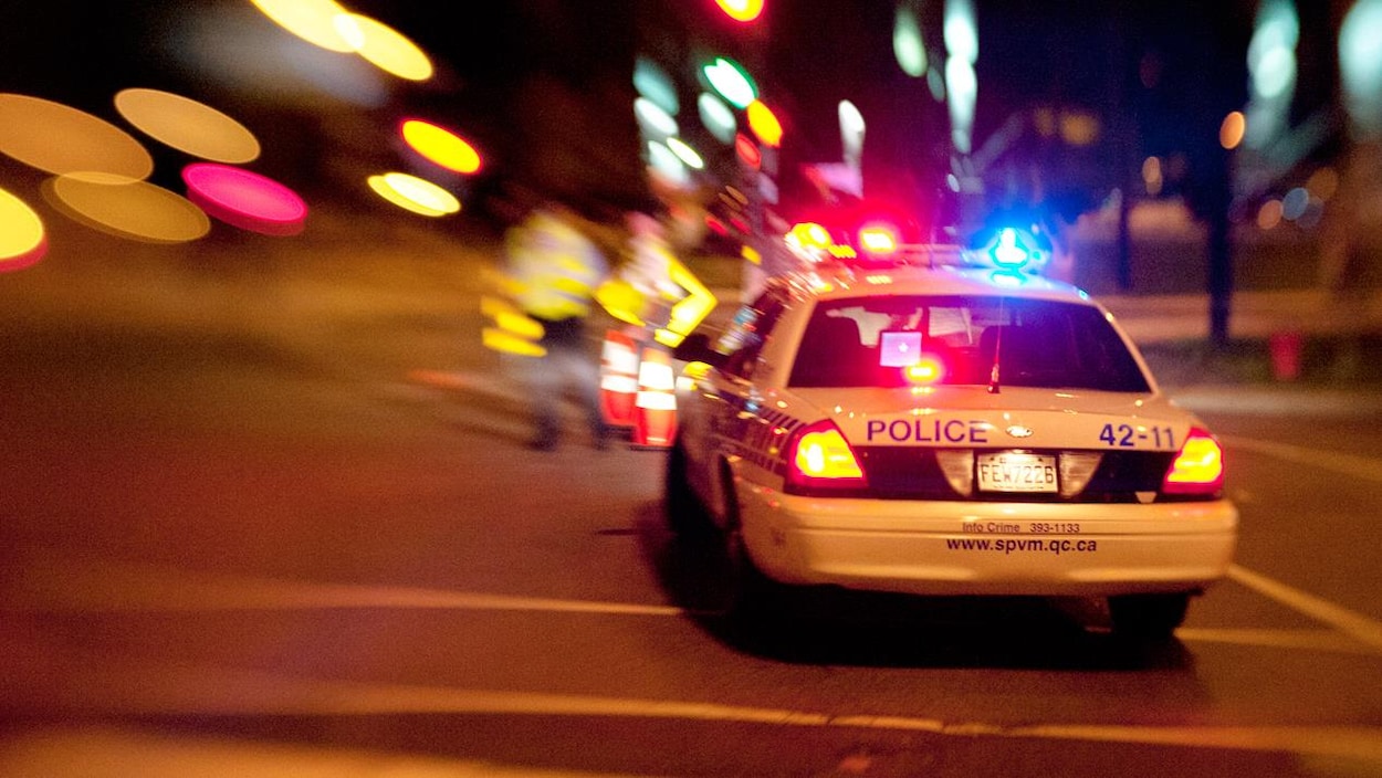 Zoom sur une auto-patrouille du Service de police de Montréal dans la nuit. Modèle désuet de Ford Crown Victoria.