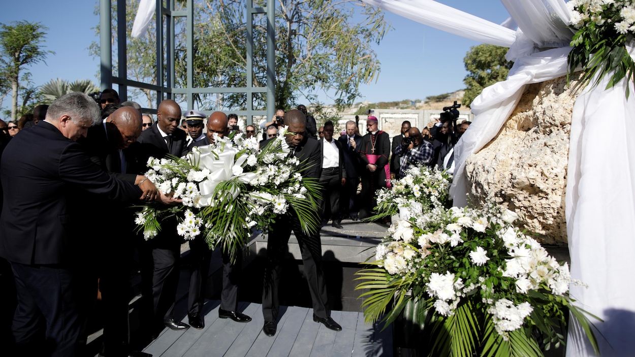 Le président haïtien Jovenel Moise et des représentants étrangers portent un bouquet de fleurs.