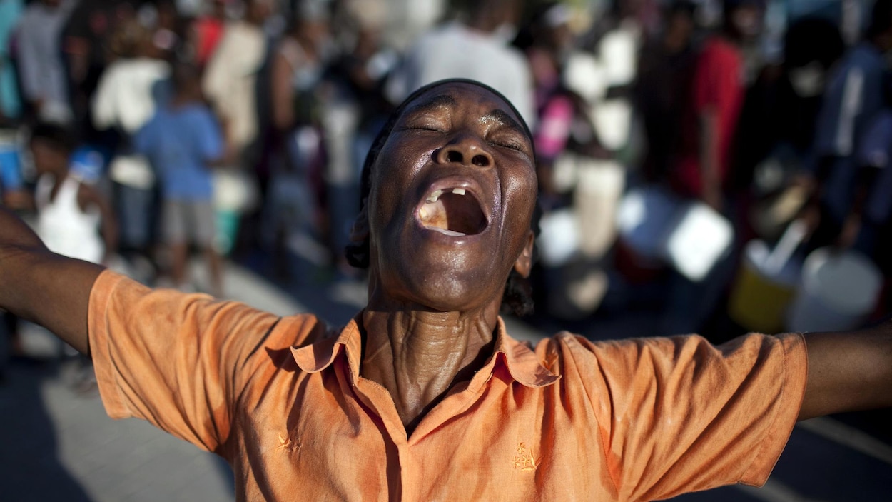 Une femme prie et chante dans une rue de Port-au-Prince, trois jours après le tremblement de terre du 12 janvier 2010.