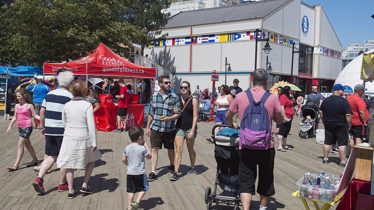 Des adultes et des enfants se promènent sur le front de mer d'Halifax en été.