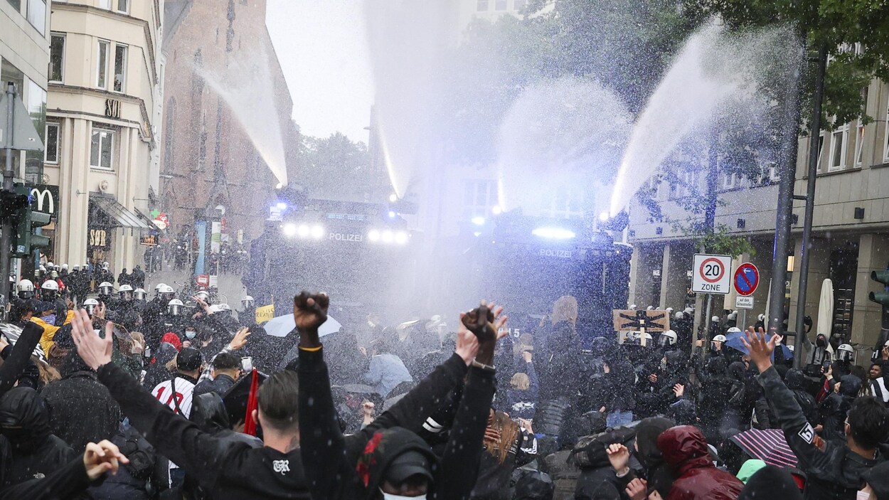 Des dizaines de manifestants se font asperger d'eau par deux camions de police.