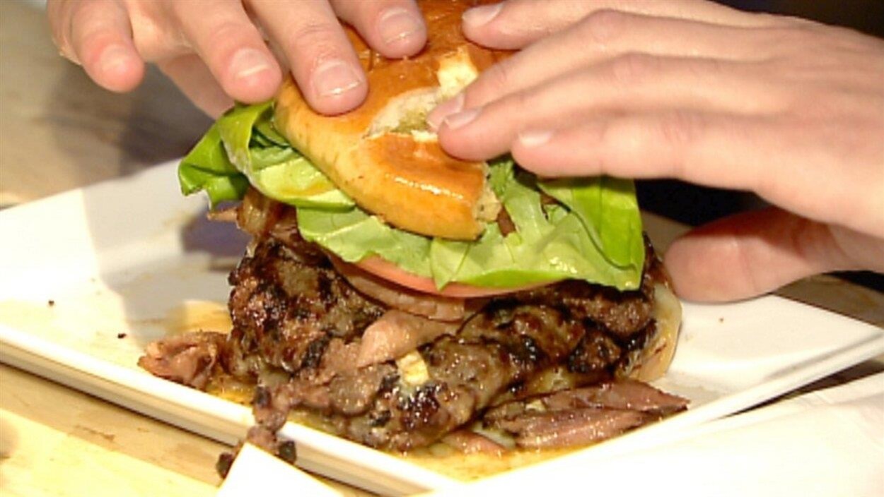 Des mains saisissent un hamburger Des mains saisissent un hamburger