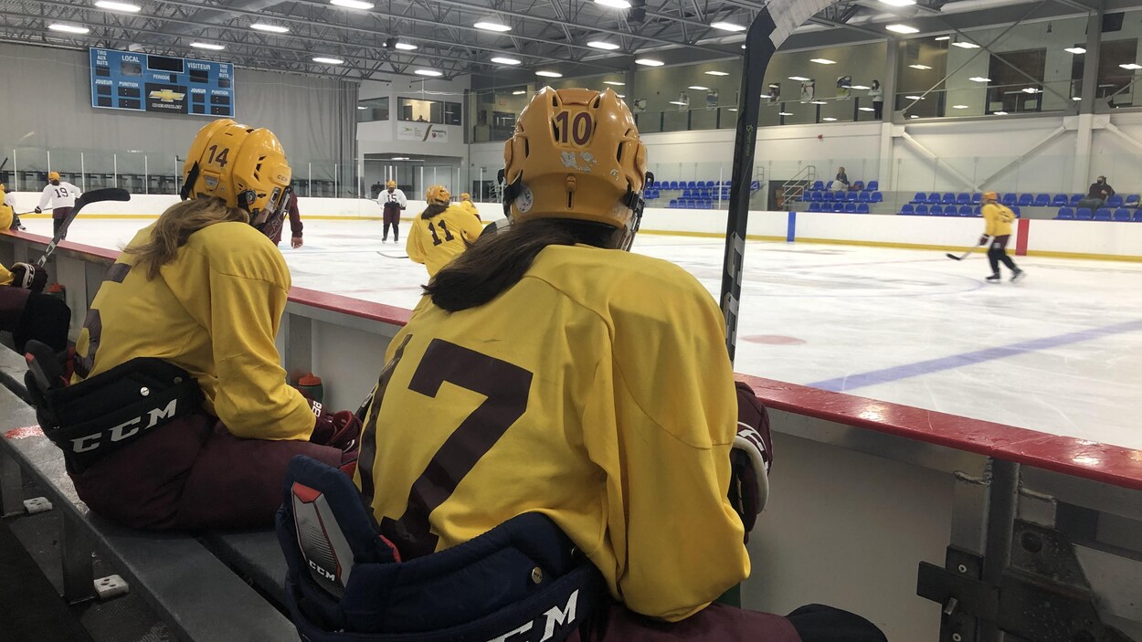 Deux joueuses de hockey assises dans les gradins du Complexe Sportif Thibault GM, à Sherbrooke.