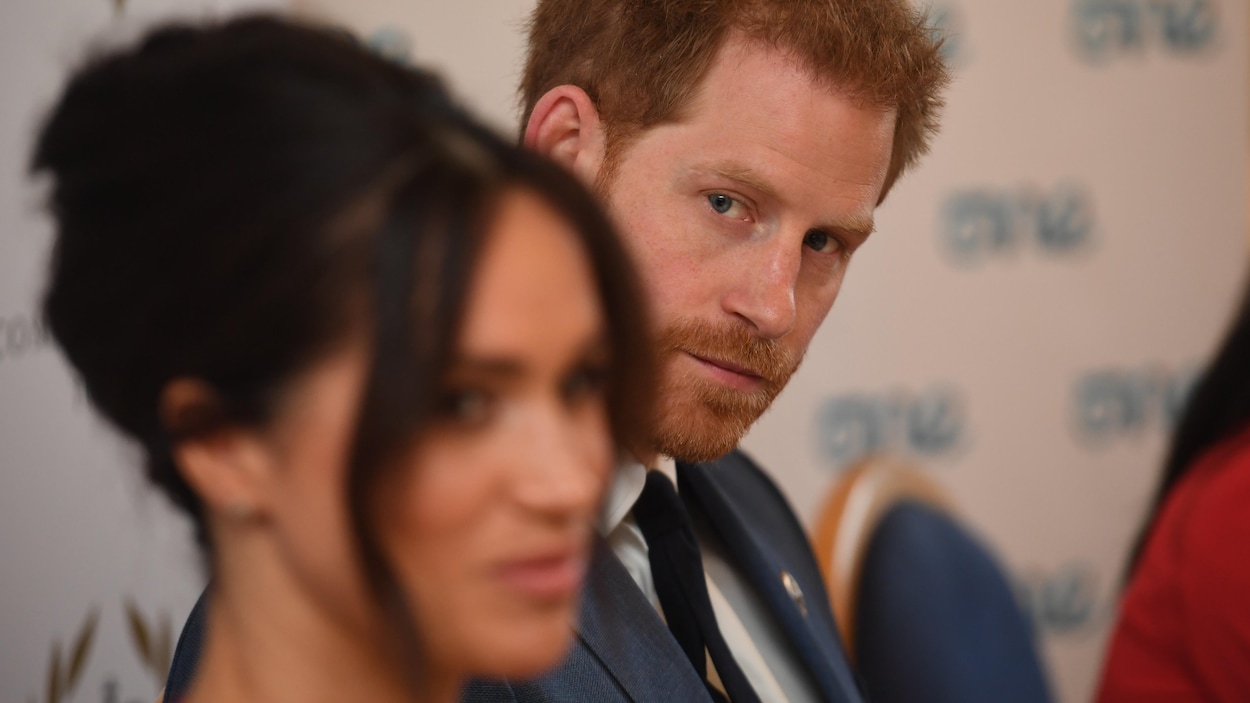Harry regarde son épouse, qui apparaît au premier plan, mais hors de la zone de netteté de la caméra.
