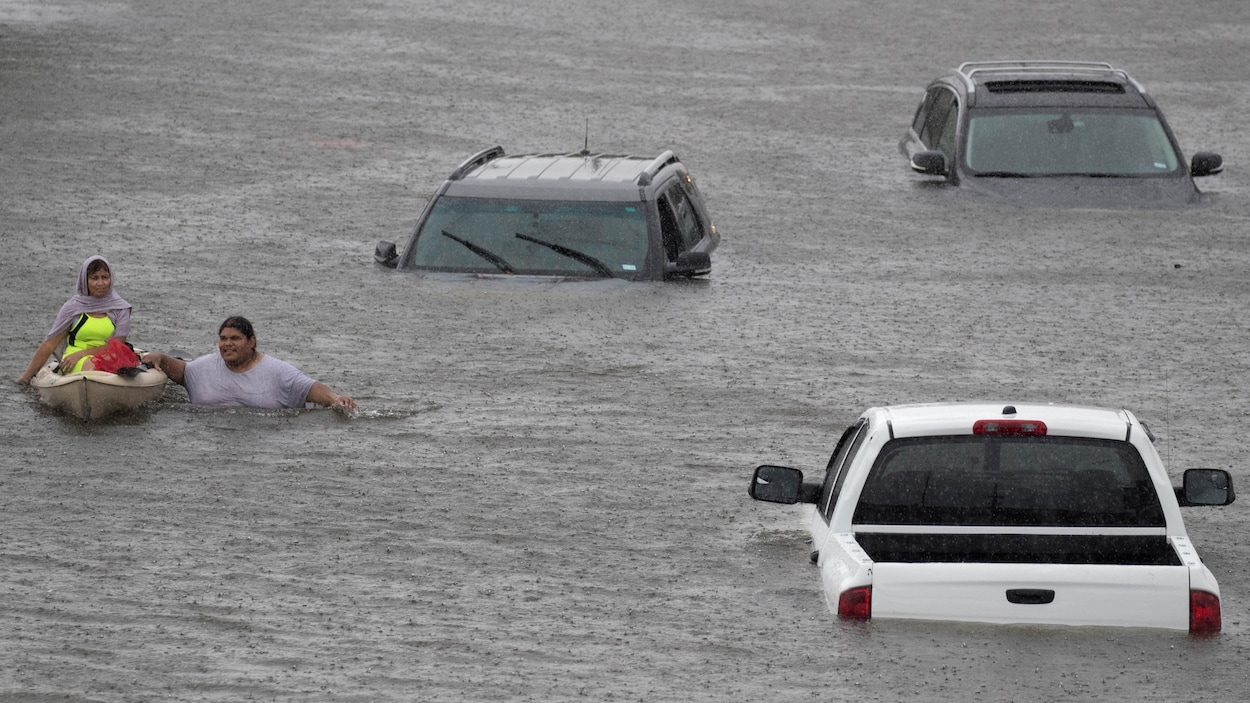 Jesus Rodriguez vient en aide à Gloria Garcia, résidente de Pearland en banlieue de Houston durement touchée par l'ouragan Harvey.