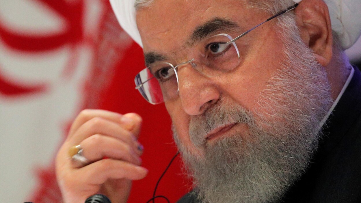 M. Rohani devant un drapeau iranien.