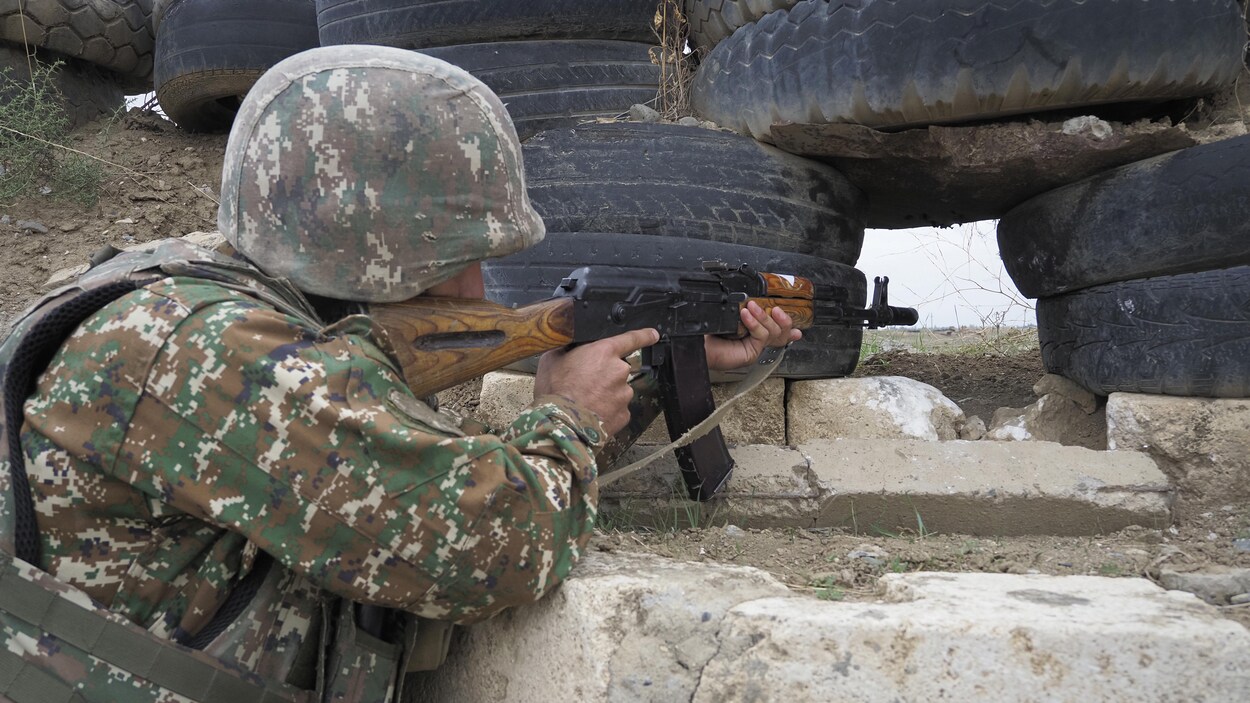 Un soldat tient un fusil mitrailleur.