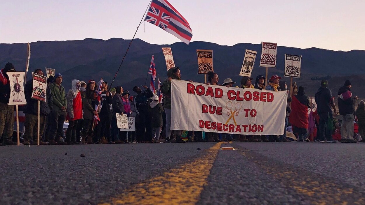 Des manifestants bloquent une route au pied de la plus haute montagne d’Hawaï, le Mauna Kea.