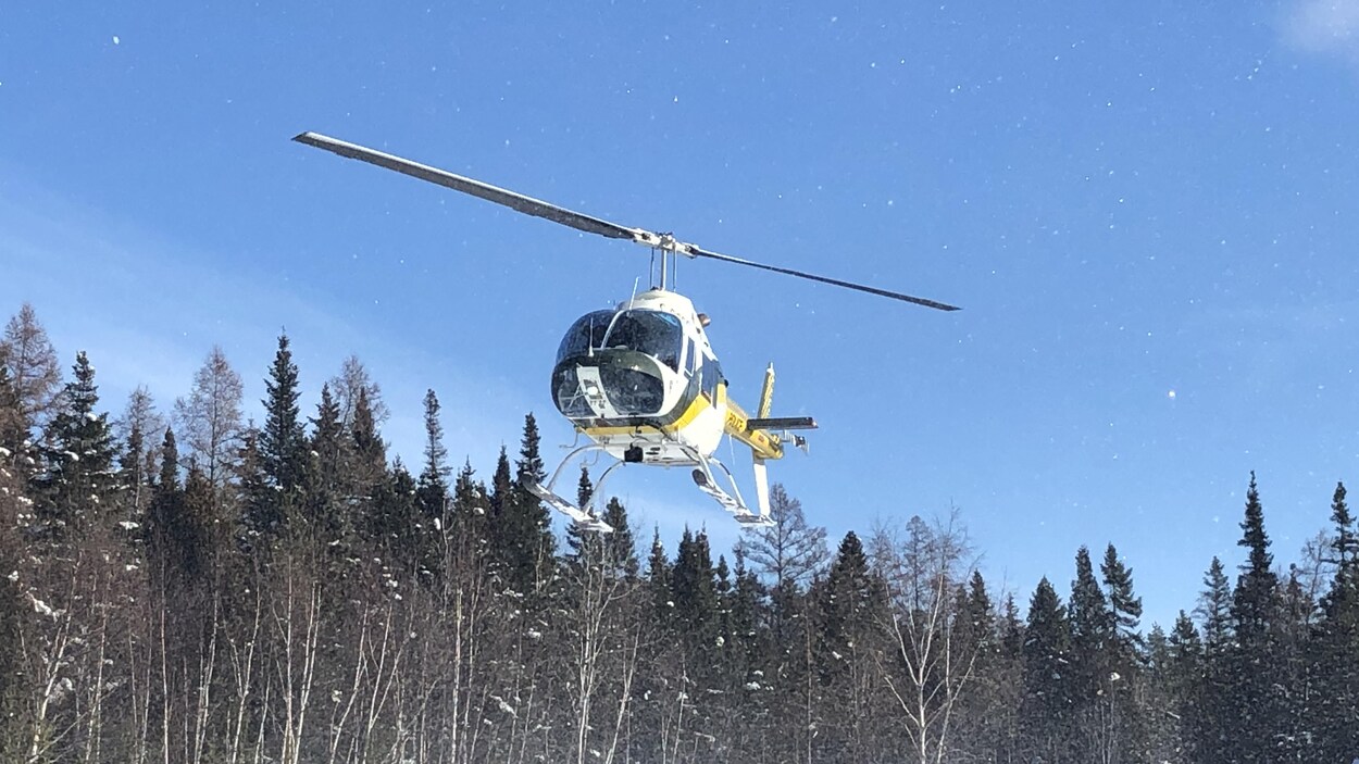 Un hélicoptère de la Sûreté du Québec se trouve dans les airs.