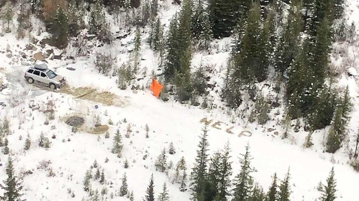 Un véhicule pris dans la neige et un message « À l'aide ».