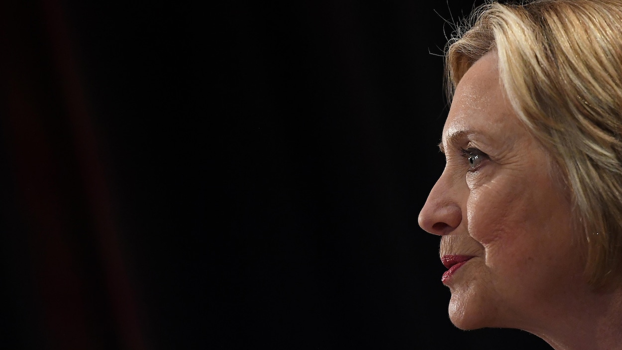 Vue de profil du visage d'Hillary Clinton sur fond noir.