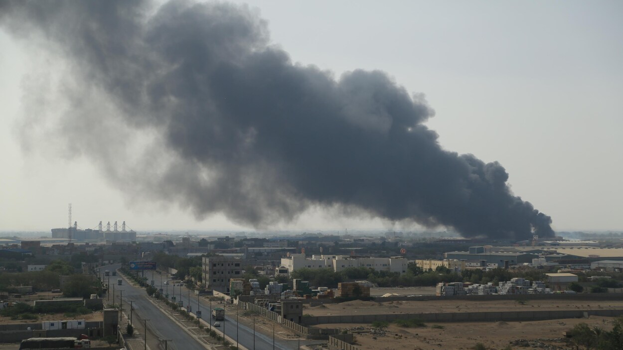 De la fumée s'échappe d'un entrepôt du Programme alimentaire mondial alors qu'un incendie l'engloutit à Hodeïda le 31 mars 2018.