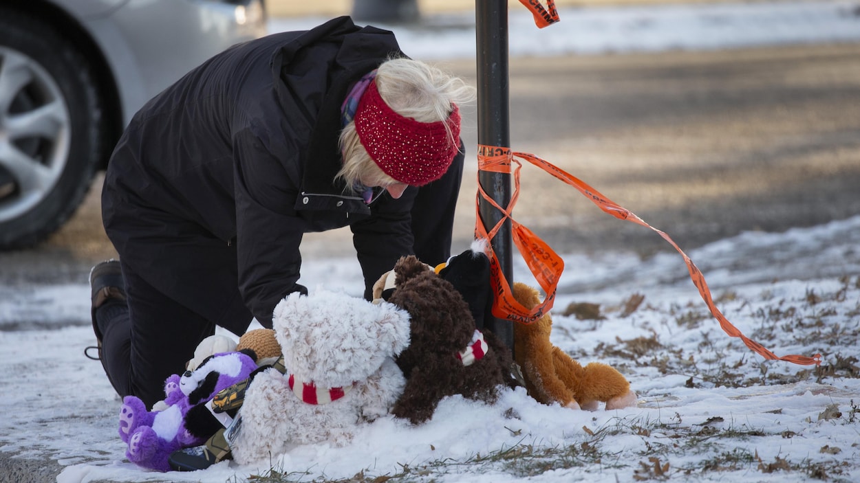 Une dame dépose un ours en peluche.