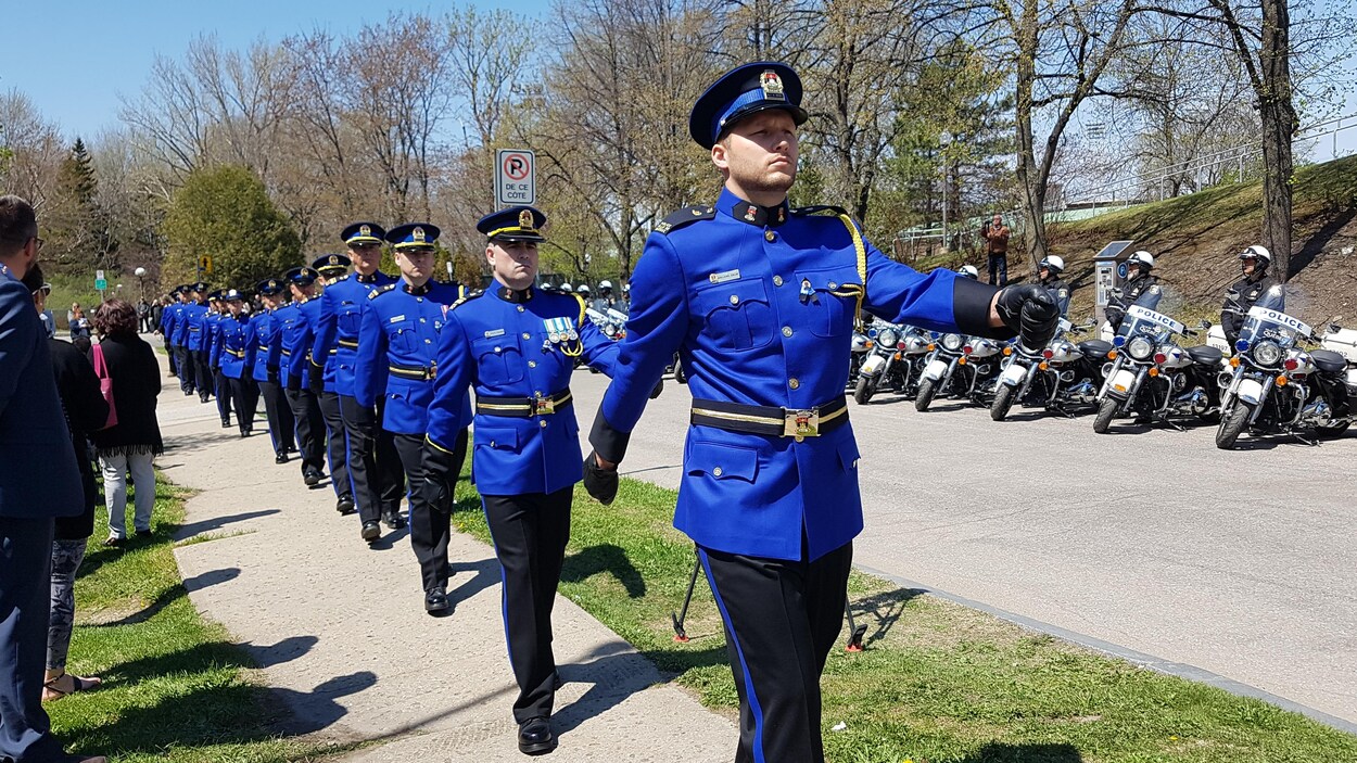 Des policiers défilent sur un trottoir Des policiers défilent sur un trottoir