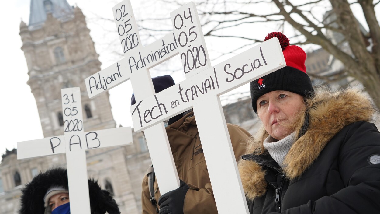 Des personnes tiennent des croix devant le parlement.