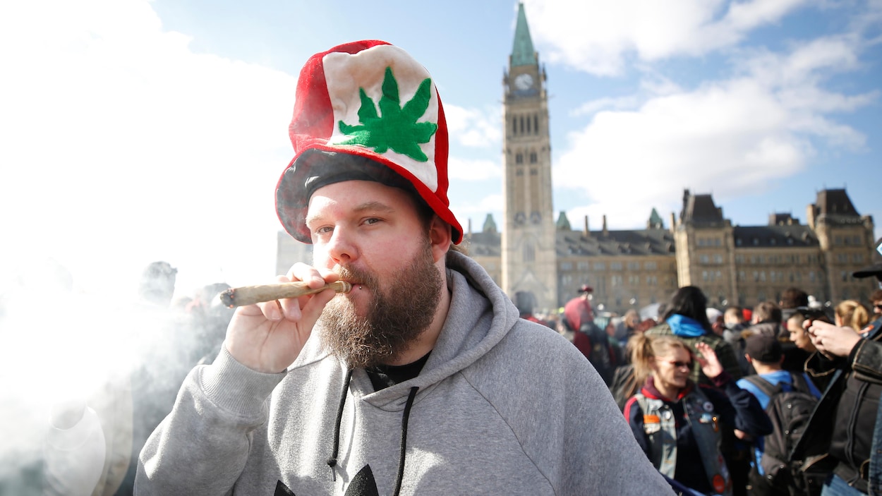 Un homme fume de la marijuana lors du rassemblement sur la colline du Parlement à Ottawa en avril 2018.