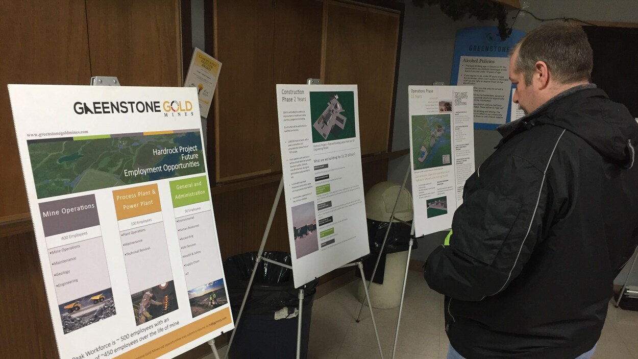 Un homme regarde des panneaux informatifs de l’entreprise Greenstone Gold Mines.