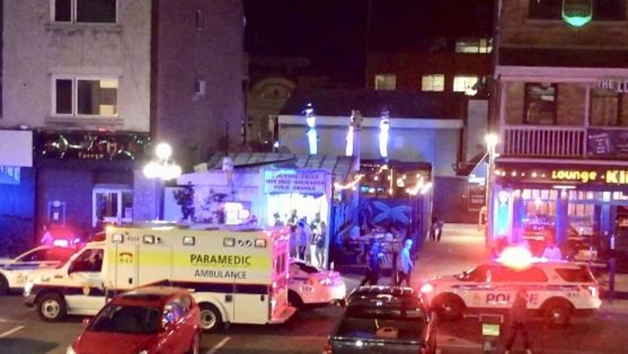 Une ambulance et une voiture Service de police d'Ottawa dans le stationnement d'un bar.