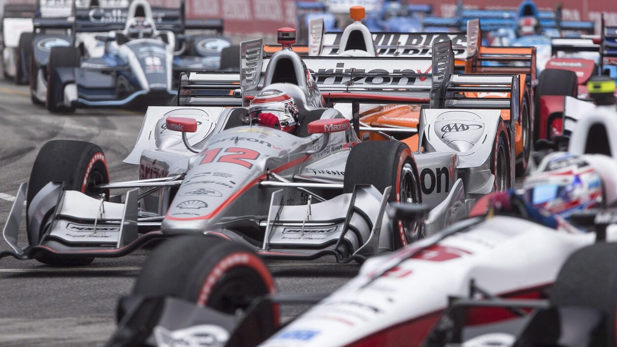 Plusieurs autos de course empruntent un virage