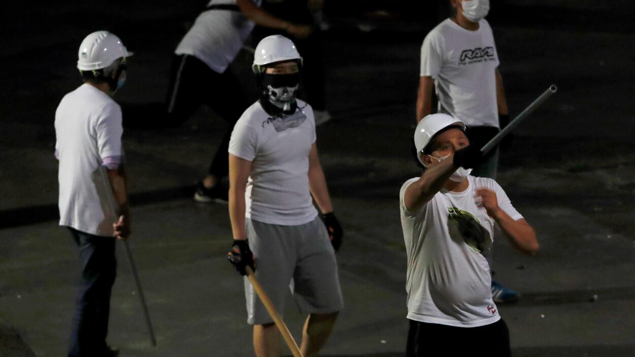 Des hommes en t-shirt portent des masques et des casques.